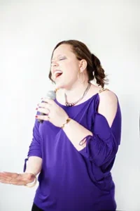 A woman wearing purple dress with white background.